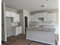Bright, unfinished kitchen features white cabinets, granite countertops and a central island at 188 Balsam Dr, Dallas, GA 30157