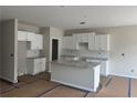 Bright, unfinished kitchen features white cabinets, granite countertops and a central island at 188 Balsam Dr, Dallas, GA 30157