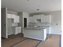 Bright, unfinished kitchen features white cabinets, granite countertops and a central island at 188 Balsam Dr, Dallas, GA 30157