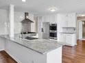Modern kitchen featuring stainless steel appliances, granite countertops, a stylish range hood, and ample cabinet space at 3725 Crescent Walk Ln, Suwanee, GA 30024