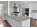 Modern kitchen featuring stainless steel appliances, granite countertops, a stylish range hood, and ample cabinet space at 3725 Crescent Walk Ln, Suwanee, GA 30024