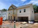 Two story home featuring large windows and an open garage in a construction phase at 4300 Easter Lily Ave Lot 11, Buford, GA 30519
