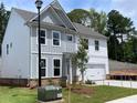 Exterior side view of a new two-story home with gray and white siding and a lush green lawn at 4300 Easter Lily Ave Lot 11, Buford, GA 30519