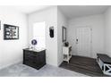 Bright entryway featuring neutral walls, dark wood floors, and stylish furnishings at 891 Feldman Chase, Loganville, GA 30052