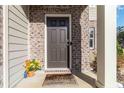 Close-up of a welcoming front door with brick and siding accents and a decorative welcome mat at 891 Feldman Chase, Loganville, GA 30052