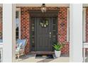 Inviting front entry with a charming floral wreath, stylish decor, and brick surround at 4675 Allistair Dr, Cumming, GA 30040