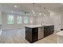 Open-concept kitchen with an island, stainless steel dishwasher, and hardwood flooring at 179 Bluffington Way, Marietta, GA 30066