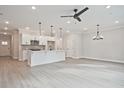 Open-concept design with kitchen island, modern light fixtures, ceiling fan, and durable luxury vinyl flooring at 175 Bluffington Way, Marietta, GA 30066