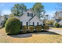 Quaint, single Gathering home featuring light gray siding and manicured landscaping with lush green bushes at 1325 Richland Creek Ct, Buford, GA 30518