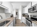 Galley kitchen design featuring white cabinetry, a tile backsplash, and stainless steel appliances at 325 E Paces Ferry Ne Rd # 504, Atlanta, GA 30305