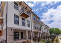 Modern townhome exterior featuring white brick, black window frames, and a charming balcony at 338 Olmstead Way # 35, Alpharetta, GA 30022