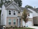 Attractive two-story home with brick and siding, complemented by a well-manicured lawn at 4375 Easter Lily Ave Lot 81, Buford, GA 30519