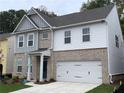 Charming two-story home featuring brick accents, gray siding, and a convenient two-car garage at 4375 Easter Lily Ave Lot 81, Buford, GA 30519