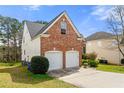 Side view of the brick home showing the two-car garage and manicured lawn at 8819 Lakecrest Way, Union City, GA 30291