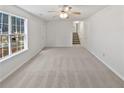 Bright living room featuring a large picture window, and a staircase leading to the second floor at 230 Nina Cir, Locust Grove, GA 30248