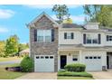 Close-up of a charming townhome featuring stone accents, well-manicured landscaping, and attached garage at 258 Ridge Mill Dr, Acworth, GA 30102