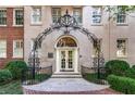 Charming building entrance with wrought iron archway and manicured landscaping at 1325 Peachtree Ne St # 402, Atlanta, GA 30309