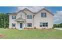 Charming two-story white brick home featuring a manicured lawn and complementary blue shutters at 193 Haverling Pass, Hampton, GA 30228