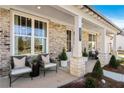Inviting covered porch with chairs, creating a cozy outdoor living space at 5120 Token Chase, Cumming, GA 30040