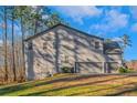 Rear view of home features a three-car garage, and access to the backyard at 205 Bergen Dr, Fayetteville, GA 30215