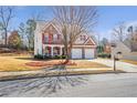 Inviting two-story home featuring red shutters, a covered porch, and an attached two-car garage at 3641 Devenwood Way, Buford, GA 30519