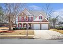 Beautiful two-story home with red shutters, a well-manicured lawn, and a two-car garage at 3641 Devenwood Way, Buford, GA 30519