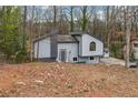 Front elevation of home with trees, vertical siding, chimney, large window and an outdoor storage shed at 1291 Marcelle Heights Pl, Norcross, GA 30093