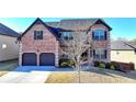 Charming two-story brick home featuring a two-car garage, manicured landscaping, and a welcoming entrance at 2640 Paddock Point Pl, Dacula, GA 30019