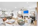 Spacious open-concept living room featuring a cozy fireplace, modern lighting, and seamless flow into the kitchen at 5765 Tillman Way, Powder Springs, GA 30127