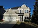 Charming two-story home featuring grey siding, a well maintained lawn, and an attached two-car garage at 101 Waters Edge Pkwy, Temple, GA 30179