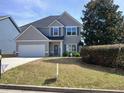 Charming two-story home with gray siding, well-manicured lawn, and an attached two-car garage at 101 Waters Edge Pkwy, Temple, GA 30179