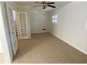 Bright and airy living room featuring plush carpeting, ceiling fan, and French doors leading to staircase at 1316 Milstead Ave, Conyers, GA 30012