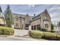 Beautiful stone home features an attached three-car garage, a circular driveway, and manicured landscaping at 4820 Marina Ln, Mableton, GA 30126