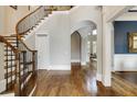 Grand foyer with a curved staircase featuring wood treads and wrought iron spindles, and an arched entry at 4820 Marina Ln, Mableton, GA 30126