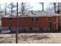 Image of the backyard of a brick home with visible basement windows and an external air conditioning unit at 754 Walnut Sw Cir, Marietta, GA 30060