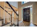 Inviting entryway with dark wood door, staircase, and luxury vinyl flooring, creating an elegant welcome at 2070 Sweetgum Trl, Cumming, GA 30041