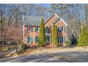 Charming brick two-story home with a well-manicured front yard and classic architectural details at 2070 Sweetgum Trl, Cumming, GA 30041