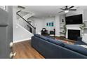 Open-concept living room featuring a fireplace, hardwood floors, and staircase at 2296 Whiteoak Se Dr, Smyrna, GA 30080