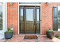 Elegant front door with glass panels, brick surround, and potted plants creating an inviting entrance at 2046 Woodside Park Dr, Woodstock, GA 30188