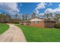 Sprawling brick home with an expansive green lawn and long driveway at 2716 Georgia 16, Carrollton, GA 30116