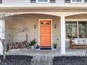 Charming front porch with an orange front door, a bench, and potted plants at 330 Knoll Woods Dr, Roswell, GA 30075