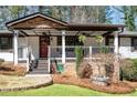 Inviting front porch with stone accents, ceiling fans, and a red front door at 3480 Dunn Se St, Smyrna, GA 30080