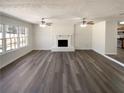 Bright living room with a fireplace, ceiling fans, and large windows at 70 Wall St, Hampton, GA 30228
