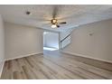 Bright living room with hardwood floors, a ceiling fan, and access to the stairway at 955 Magnolia Gardens Walk, Mcdonough, GA 30253