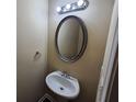 Powder room featuring a pedestal sink with an oval mirror and lighting above at 203 August West Way, Lawrenceville, GA 30046