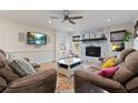 Cozy living room with a stone fireplace, plush seating, and a large TV, ideal for relaxation and entertainment at 6510 Akins Way, Cumming, GA 30041