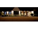 Captivating night shot of a well-lit home showcasing its elegant design and professionally landscaped front yard at 165 Sugarland Trl, Fayetteville, GA 30214