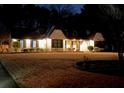 Night view of a beautifully lit home highlighting its architectural details and inviting curb appeal on a spacious lot at 165 Sugarland Trl, Fayetteville, GA 30214