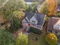 Aerial view of a two-story home with a brick facade, gabled roof, and a tree-filled lot at 1824 Windemere Ne Dr, Atlanta, GA 30324