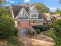 Beautiful two-story home with brick facade, prominent gables, and lush landscaping at 1824 Windemere Ne Dr, Atlanta, GA 30324